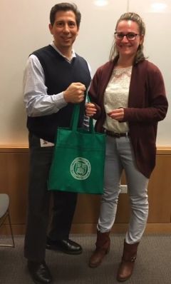 Man and woman posing for photo with green bag